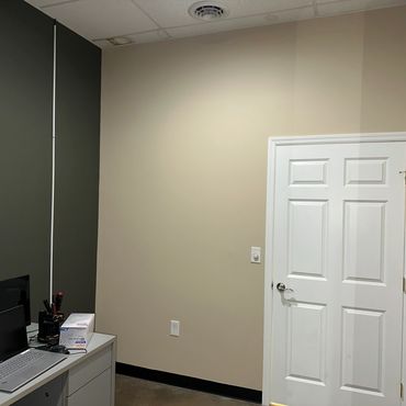 Minimalist office corner with laptop and a closed white door.