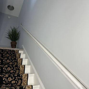 Carpeted stairs with floral pattern and a potted plant at the top.