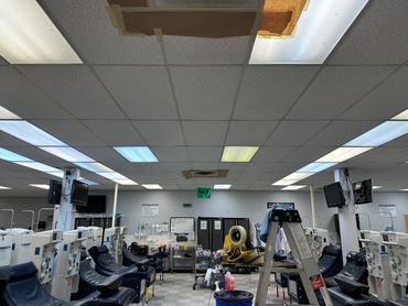 Interior of a medical donation center with rows of chairs and machines.