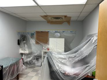 A medical room covered in protective plastic sheeting, possibly for renovation or cleaning.