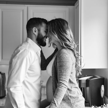 Expecting couple sharing an intimate moment in the kitchen.