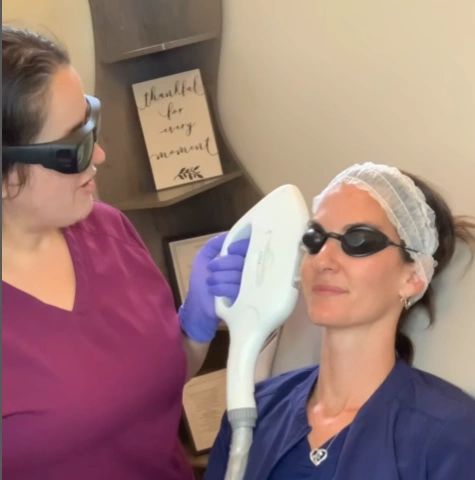 Woman receiving a facial laser treatment from a professional.