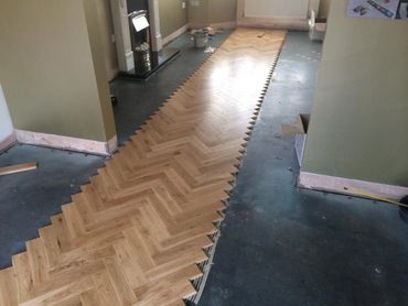 The first process in the pre-finished herringbone solid oak parquet fitting and repair