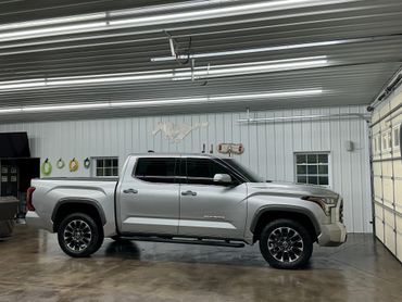 Silver Toyota Tundra pickup truck parked inside a well-lit garage.