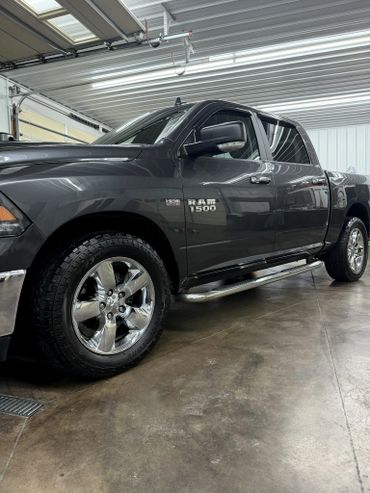 Shiny black Ram 1500 truck inside a garage.