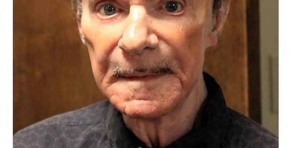 Close-up portrait of an elderly man with a serious expression.