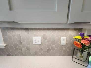 Kitchen remodel with white cabinets and leaf pattern grey backsplash