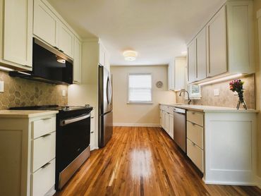 Kitchen remodel with white cabinets and leaf pattern grey backsplash
