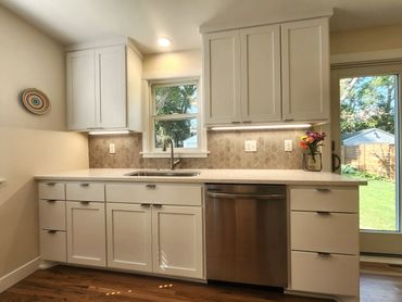 Kitchen remodel with white cabinets and leaf pattern grey backsplash