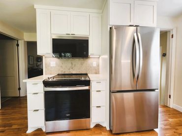 Kitchen remodel with white cabinets and leaf pattern grey backsplash