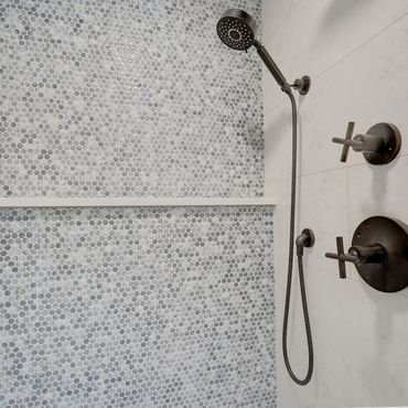 Blue penny round tiles in shower with black shower fixtures