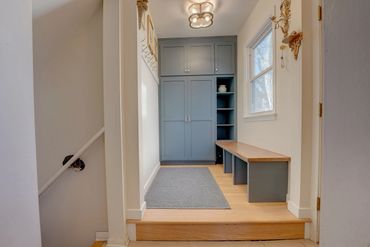 Mudroom addition with blue cabinets and wood top bench