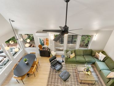 Modern living and dining area with green sofa and black dining table.