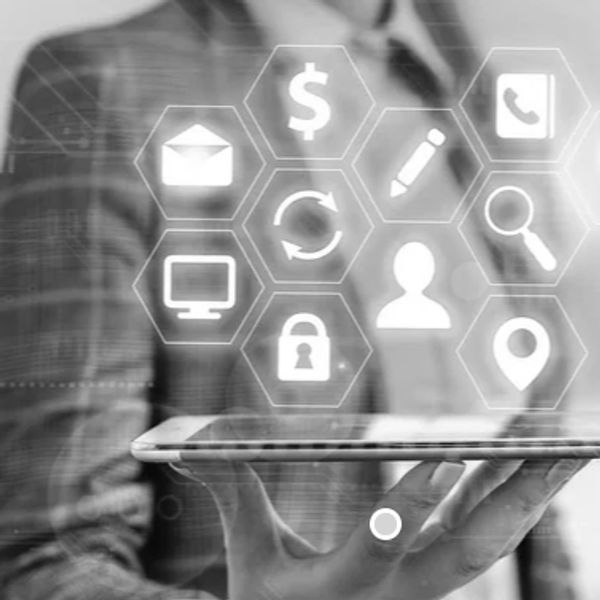 Businessman holding a tablet with digital icons hovering above it.