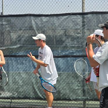 SCHP Tennis coach giving technique instruction to a junior player