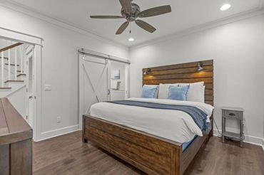 Cozy bedroom with wooden bed frame and ceiling fan.