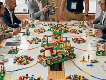 Personas en una reunión con juguetes de construcción.