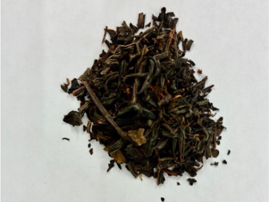 Loose tea leaves on a white surface.