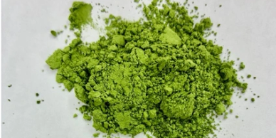 Pile of green powder on white surface.
