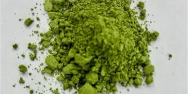 Green powdered substance on white surface.