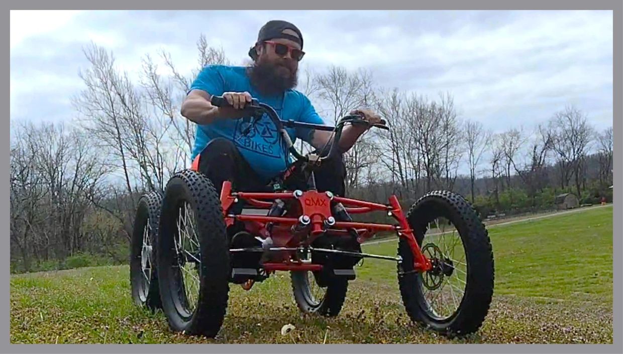 Man riding a four-wheeled off-road vehicle on grass.
