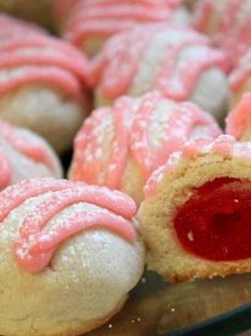 Pink frosted cookies with red jelly centers.
