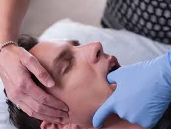 Person having jaw massaged.