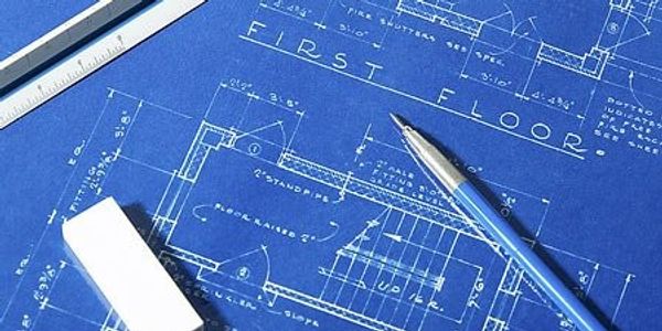 Architectural blueprint with pen, eraser, and ruler on a workspace.