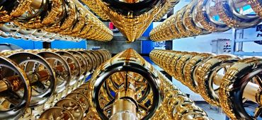 Rows of shiny golden rings on metal rods in an industrial setting.