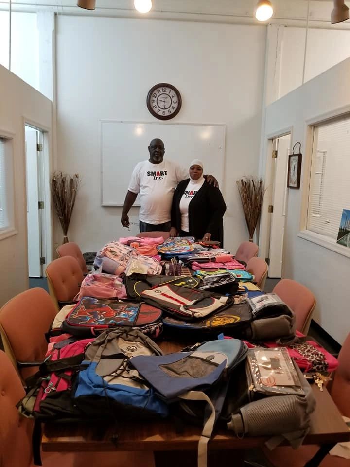 In the Smart office Jaffar and Rabia prepare for the Smart Inc. back to school book bags and school supply giveaway.