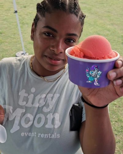 happy customer holding a cup of strawberry philly water ice