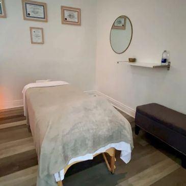 Cozy massage therapy room with a massage table and calming decor.