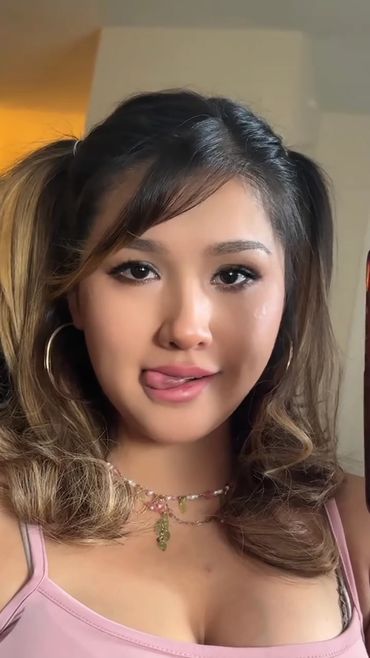 Young woman licking lips in a pink tank top