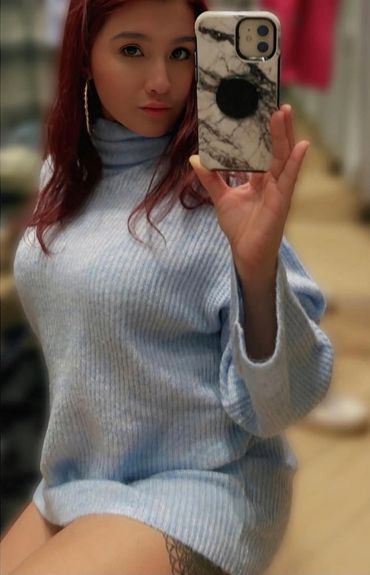 Young woman tak8ng selfie in short dress before filming show auntiez