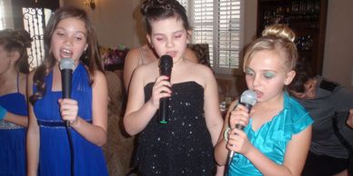 glamorous girls in party dresses sing karaoke at a rock star party