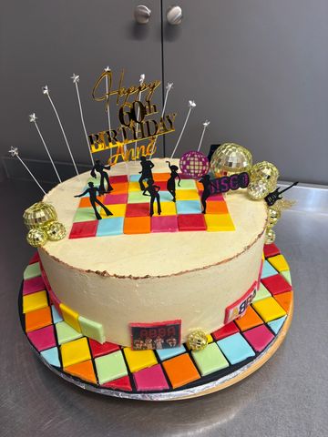 Colorful disco-themed 60th birthday cake with dancing silhouettes and disco balls.