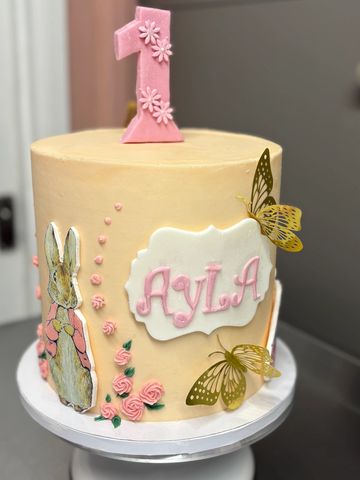 Elegant first birthday cake with butterflies and a bunny.