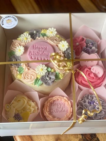 Elegant birthday cake set with floral decorations and pastel colors.