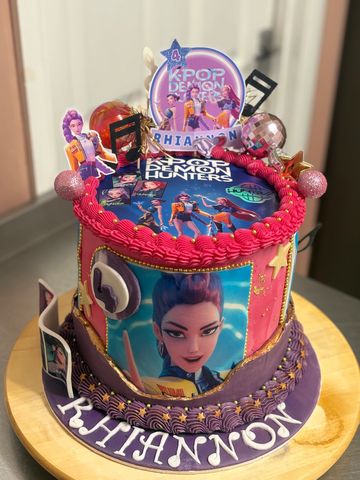 Colorful K-pop themed birthday cake with vibrant decorations and character images.