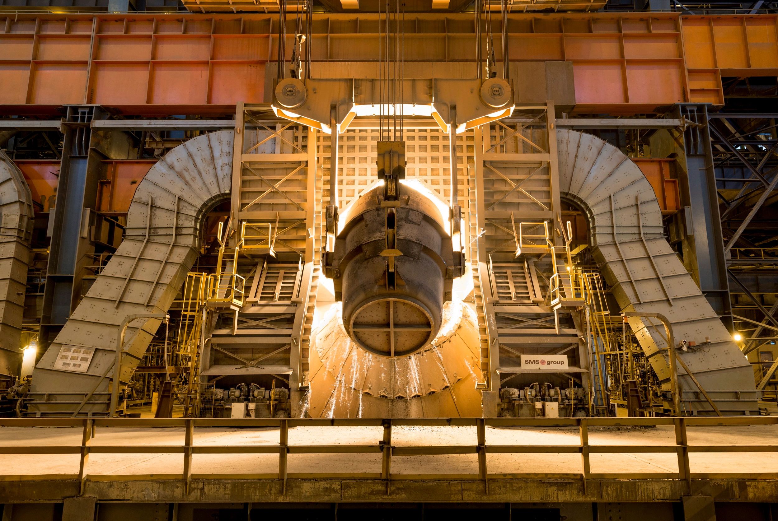 Industrial steel furnace pouring molten metal in a factory.