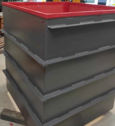 Large black metal container with a red rim. lined with red rubber sheeting