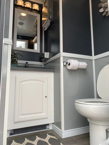 2 stall restroom trailer interior- female. Gray walls, toilet and sink.