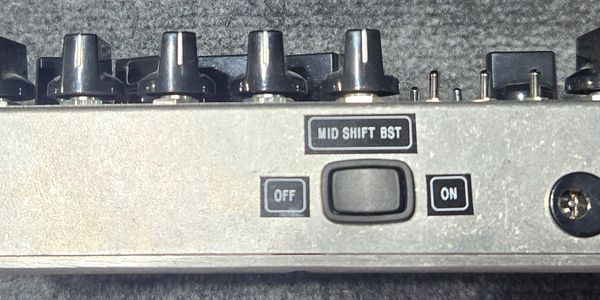 Side view of a metal device with knobs and a toggle switch labeled ON and OFF.