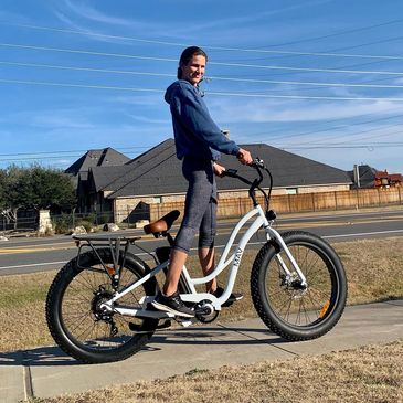 A MAV rider on a white MAV Step Through electric bike.  This cruiser features our 26" fat tires.