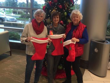 Darlene Griffin & Tommae Sligh with a Park Ridge Hospital representative showing Christmas Stockings