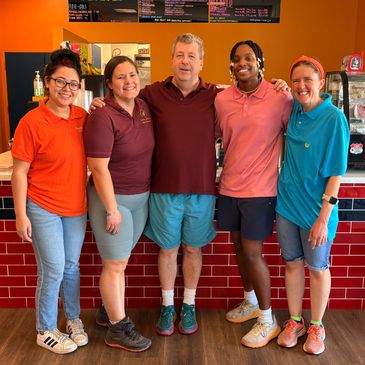The Cup of Joey team standing in front of the counter at the coffee shop.