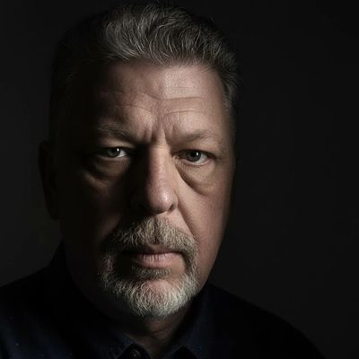 Stephen Rice (Mi Yichen, 米翊宸), Artist. Close-up portrait of a serious middle-aged man with a beard against a dark background.