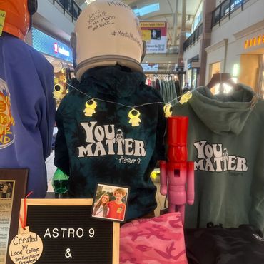 Hoodies with 'You Matter' slogan and astronaut design displayed in a store.