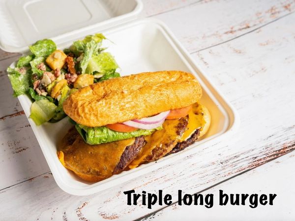 Triple long cheeseburger with fresh salad in a to-go container.