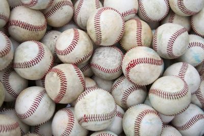 Pile of multiple used baseballs.